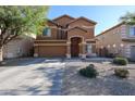 Charming two-story home with a well-maintained lawn, mature tree, and desert landscaping at 10037 W Chipman Rd, Tolleson, AZ 85353