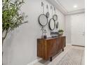 Stylish entryway with a wood console table, round mirrors, and decorative accents at 10454 W Maya Way, Peoria, AZ 85383