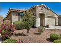 Well-maintained home showcasing desert landscaping, rock mulch, and mature flowering bushes at 10454 W Maya Way, Peoria, AZ 85383