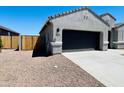 Attached two-car garage with concrete driveway and desert landscaping for easy maintenance at 11894 E Aster Ln, Florence, AZ 85132