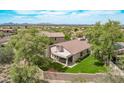 An aerial view of a backyard with mature trees, green grass, and a patio at 15691 N 104Th Pl, Scottsdale, AZ 85255