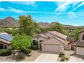 Charming single-story home boasts a tile roof, well-manicured landscaping, and picturesque mountain views at 15691 N 104Th Pl, Scottsdale, AZ 85255