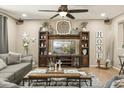 Comfortable living room with sectional sofa, ceiling fan, and entertainment center with decorative accents at 19305 E Oriole Way, Queen Creek, AZ 85142