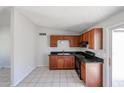 Updated kitchen with cherry cabinets, black appliances, and tile flooring at 3646 N 69Th Ave # 4, Phoenix, AZ 85033