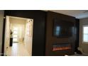Living room featuring a fireplace, dark accent wall, and light flooring at 4090 S Virginia Way, Chandler, AZ 85249