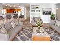 Inviting living room featuring comfortable seating, a stylish rug, and seamless flow into the kitchen at 41220 N Belfair Way, Anthem, AZ 85086