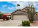 Desert home with tile roof, palm trees and a two-car garage and desert landscaping at 6014 E Sayan Cir, Mesa, AZ 85215