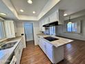 Bright kitchen with white cabinets, granite counters, and an island cooktop, open to the dining area at 6410 N 82Nd Way, Scottsdale, AZ 85250