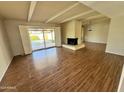 Spacious living room featuring wood-look tile flooring, a fireplace, and access to the pool area at 6410 N 82Nd Way, Scottsdale, AZ 85250
