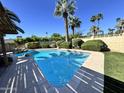 Inviting pool surrounded by lush landscaping and palm trees, perfect for outdoor relaxation at 6410 N 82Nd Way, Scottsdale, AZ 85250