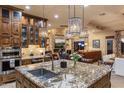 Gourmet kitchen featuring granite counters, stainless appliances, an island, and stone accents at 6888 E Mighty Saguaro Way, Scottsdale, AZ 85266