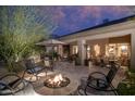 Outdoor patio with a fire pit, comfortable seating, and an outdoor cactus art piece at 6888 E Mighty Saguaro Way, Scottsdale, AZ 85266