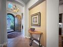 Elegant foyer with a decorative table and picture, showcasing tile flooring and an arched doorway at 8964 E Mountain Spring Rd, Scottsdale, AZ 85255
