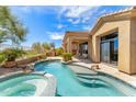 Beautiful backyard oasis showcasing a swimming pool, spa, covered patio, and well-manicured landscaping at 9327 E Whitewing Dr, Scottsdale, AZ 85262