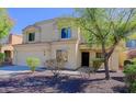 A tan two-story home with well-maintained landscaping and a two-car garage is seen on a sunny day at 9541 W Frank Ave, Peoria, AZ 85382