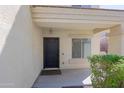 Covered porch with a black front door, matching hardware, and a small window on the side at 9541 W Frank Ave, Peoria, AZ 85382