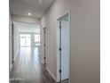 Bright hallway with modern tile flooring and access to various rooms, offering a glimpse into the home's layout at 18220 W Daley Ln, Surprise, AZ 85387