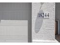 Close-up of house number 18244 affixed to the stucco exterior next to the garage door at 18244 W Daley Ln, Surprise, AZ 85387