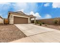 Single-story home featuring a two-car garage and low-maintenance desert landscaping and a long driveway at 10347 S Saguaro Dr, Apache Junction, AZ 85120