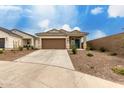 Inviting single-story home with a desert-style landscaped front yard and a blue front door at 10347 S Saguaro Dr, Apache Junction, AZ 85120