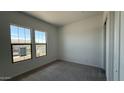 Bright bedroom featuring a large window with beautiful views, plush carpeting, and ample natural light at 11432 E Utopia Ave, Mesa, AZ 85212