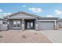 Charming single-Gathering home showcasing a gray exterior, brick accents, and a paved driveway at 11432 E Utopia Ave, Mesa, AZ 85212