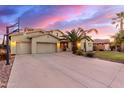 Expansive driveway leads to a three-car garage and beautifully landscaped front yard with mature palm trees at 1147 E Lodgepole Dr, Gilbert, AZ 85298