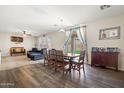 Open-concept living room and dining area, with hardwood floors, plush furniture, and natural light at 11732 W Foothill Dr, Sun City, AZ 85373