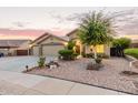 Charming single-story home featuring a three-car garage and a well-maintained, xeriscaped front yard at 136 N 236Th Ave, Buckeye, AZ 85396