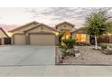 Charming single-story home featuring a three-car garage and a well-maintained, xeriscaped front yard at 136 N 236Th Ave, Buckeye, AZ 85396