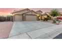 Charming single-story home featuring a three-car garage and a well-maintained, xeriscaped front yard at 136 N 236Th Ave, Buckeye, AZ 85396