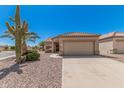 Desert home featuring rock landscaping, tile roof, and two-car garage at 16115 W Acacia Ct, Surprise, AZ 85374