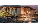 Attractive front yard showcasing desert landscaping, subtle lighting, and a pathway to the front door at 16422 W Alvarado Dr, Goodyear, AZ 85395