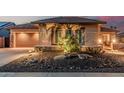 Exterior view showcasing a desert landscape, exterior lighting, and a well manicured lawn at 16422 W Alvarado Dr, Goodyear, AZ 85395
