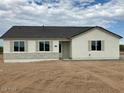 Stylish single-story home boasting white siding, decorative shutters, and gray stone accents at 22113 W Laura St, Wittmann, AZ 85361