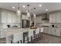 Bright, modern kitchen with stainless steel appliances, a spacious island, and stylish pendant lighting at 27629 N 176Th Dr, Surprise, AZ 85387