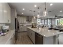 Open kitchen with stainless appliances, white countertops, and an island, flowing into the living area at 27629 N 176Th Dr, Surprise, AZ 85387
