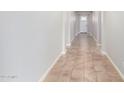 Hallway features neutral paint, light tile flooring, and leads to a white door with decorative glass at 2831 W Carson Rd, Phoenix, AZ 85041