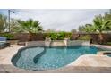 Backyard pool and spa are surrounded by travertine patio, lush landscaping, and privacy walls at 29854 N 132Nd Dr, Peoria, AZ 85383