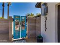 Charming front gate with distressed blue doors and potted succulents on a sunny day at 3117 E Campbell Ave, Phoenix, AZ 85016