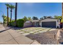 Stylish home with a concrete driveway, desert landscaping, and an inviting blue entry gate at 3117 E Campbell Ave, Phoenix, AZ 85016