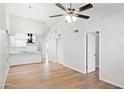 Spacious living room with wood floors, ceiling fan, and open access to the kitchen at 3326 E Calypso Ave, Mesa, AZ 85204