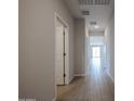 Bright hallway featuring tile flooring and neutral paint, leading to various rooms in the home at 39970 W Bravo Dr, Maricopa, AZ 85138