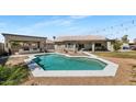 Inviting backyard oasis with a sparkling pool, outdoor kitchen, fire pit, and ample patio space for entertaining at 4115 S 75Th Dr, Phoenix, AZ 85043
