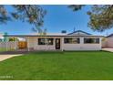 Inviting home with fresh curb appeal, showcasing its manicured lawn and stylish exterior details at 7507 E Beatrice St, Scottsdale, AZ 85257