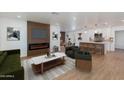 Bright, open living room featuring a modern fireplace, hardwood floors, and a seamless flow to the kitchen at 7507 E Beatrice St, Scottsdale, AZ 85257