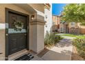 Inviting front door featuring a decorative wreath and a covered entry, complemented by manicured landscaping at 927 W Wendy Way, Gilbert, AZ 85233