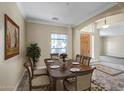 Formal dining room with a dark wood table set for six, a large window, and neutral décor at 12733 S 177Th Ln, Goodyear, AZ 85338