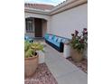 Inviting front porch with blue cushioned seating and decorative potted plants offering a cozy outdoor living space at 12945 W El Sueno Ct, Sun City West, AZ 85375
