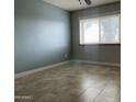 A cozy bedroom with soothing blue walls, tiled floors, and a window with natural light at 19322 E Calle De Flores --, Queen Creek, AZ 85142